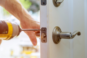 Installation locked interior door knobs, close-up woodworker hands install lock.