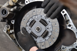 Man holding a silver metal vehicle clutch